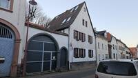 Giebelständiges, verputztes, zweigeschossiges Wohnhaus mit Satteldach und rundbogiger Toreinfahrt mit Mannpforte.