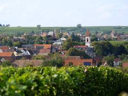 Das Bild zeigt die Ortsansicht des Ortes Flörsheim-Dalsheim. Zu sehen ist im Vordergrund einer der drei Kirchtürme, der im Ortsteil Niederflörsheim steht und zur evangelischen Kirche gehört.