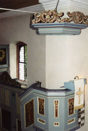 Das Bild zeigt die Kanzel in der evangelischen Kirche mit geschnitztem Schalldeckel.