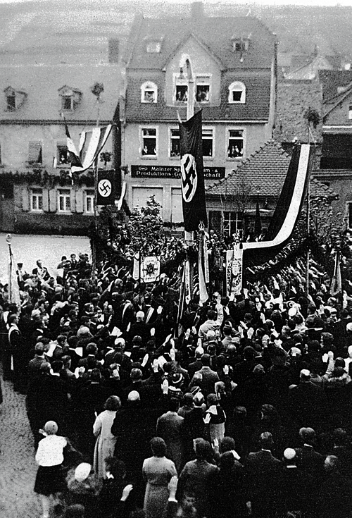 Abb. 5: Pflanzung der Hitler-Eiche mit zahlreichen Vereinsfahnen, im Hintergrund das Haus der Mainzer Spar-, Konsum- und Produktions-Genossenschaft.