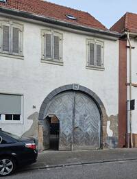 Das spätbarocke Wohnhaus in der Herrnsheimer Hauptstraße 36 verfügt über eine originale, rundbogige Toreinfahrt. Deren Scheitelstein ist mit der Abbildung eines Pferdes geschmückt und ist mit der Jahreszahl 1773 bezeichnet.