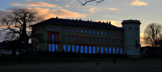 Blick auf das Herrnsheimer Schloss vom Schlosspark. Links sieht man den Kirchturm der Pfarrkirche St. Peter.