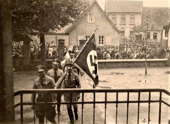 NS-Aufmarsch in der Schlossstraße Udenheim. Im giebelständigen Haus lebte Katharina Edinger, geb. Kahn.