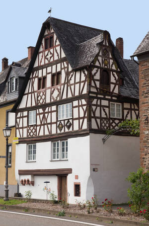 Das Storchenhaus in Bremm. Historisches Fachwerkhaus mit namensgebendem Storch im Brüstungsfeld des Prunkfensters.
