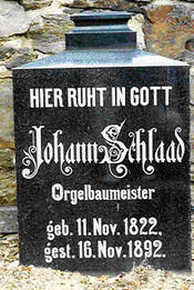 Das Foto zeigt die Replik des schwarzen Gedenksteines, in den eingraviert ist: "Johann Schlaad, Orgelbaumeister, geboren 11. November 1822, gestorben 16. November 1892".